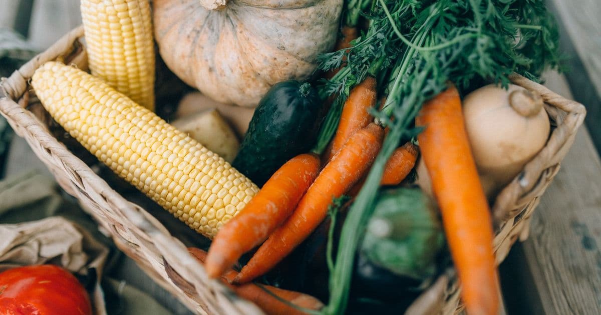 A close-up of fresh organic vegetables in a wicker basket, perfect for healthy eating.